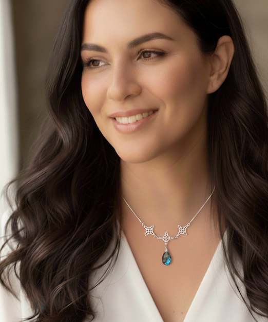 mujer con collar de plata que lleva 3 nudos de bruja y una piedra labradorita 