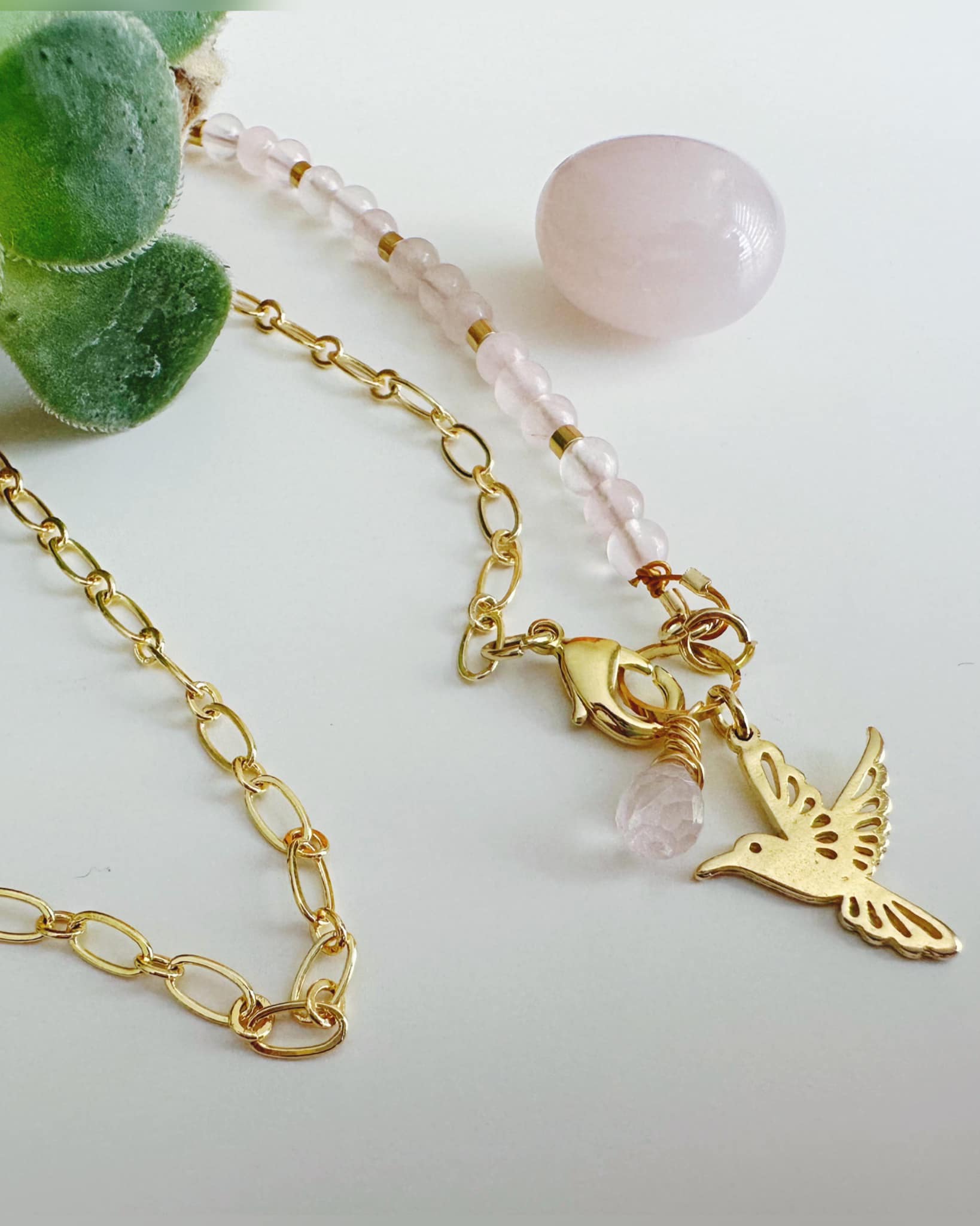 collar de colibri en piedras de cuarzo rosa y cadena baño de oro 18k. lleva un colibri y una piedra con forma de gota junto al colibri