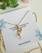collar bañado en oro 18k de cadena fina con corazon doble y piedra de cuarzo rosa sobre una tarjeta con mensaje especial
