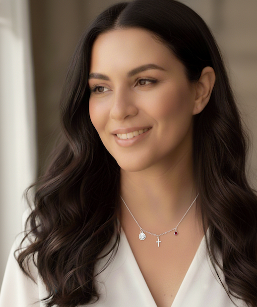 mujer con collar que tiene un san benito, crusz de cristo y punto de luz rojo