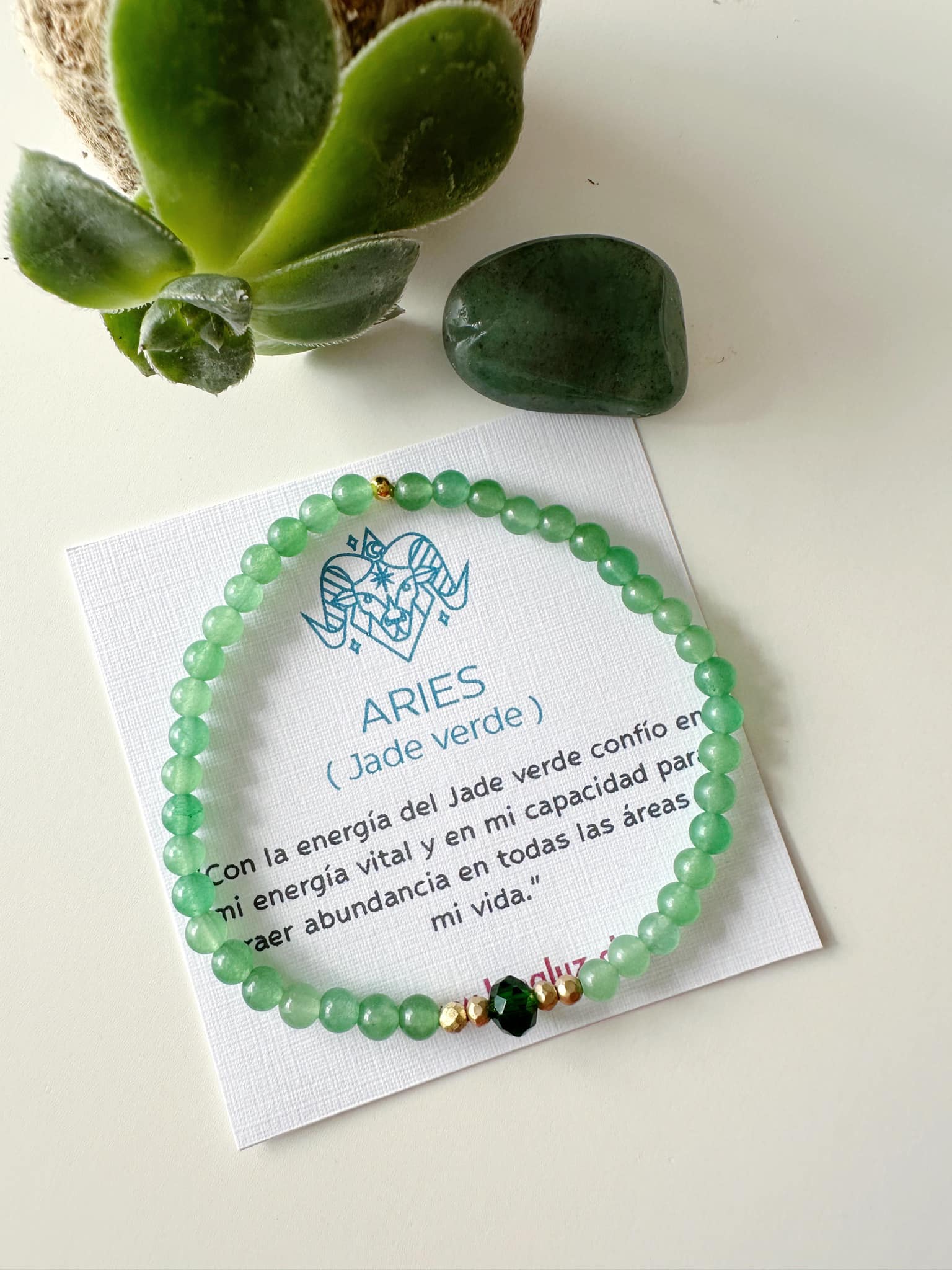 pulsera en piedra jade verde elasticada con tarjeta que explica el significado de la piedra y el signo de aries